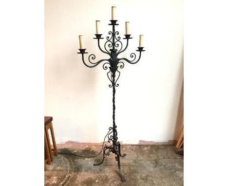 A large floor standing metal candelabra with five faux candles above drip trays, on C scroll and acanthus leaf supports, with