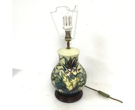 A Moorcroft table lamp of baluster form and decorated with water lilies and other flowers, on circular wooden base (35cm to t