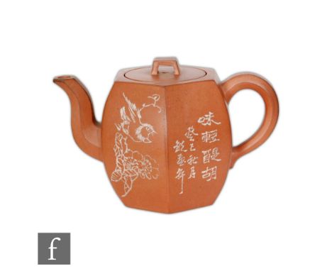 A Chinese Yixing teapot of rounded hexagonal form with loop handle, the exterior sides painted inscribed with lines of charac