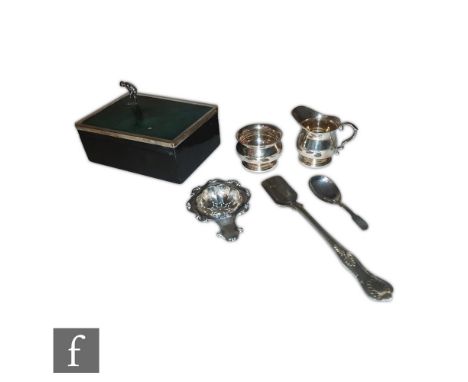 A small parcel lot of hallmarked silver, a cheese scoop, a cream and sugar, a tea strainer, a caddy spoon and a  silver and w