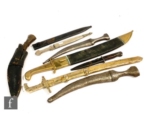 Three Eastern daggers, a similar replica sword, an Indian brass short sword, a Kukri, a bayonet stamped 9085 and a spare scab