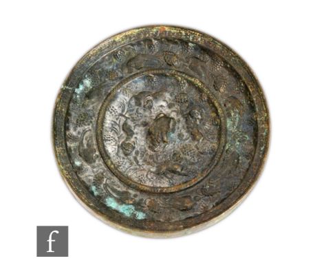 A Chinese Ming Dynasty (1368-1644) bronze mirror, the circular mirror cast with segmented borders, filled with fruiting vines