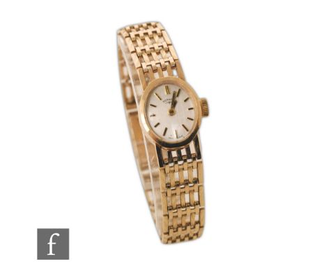 A lady's 9ct hallmarked Rotary manual wind wrist watch, gilt batons to an oval silvered dial and integral four bar gate brace