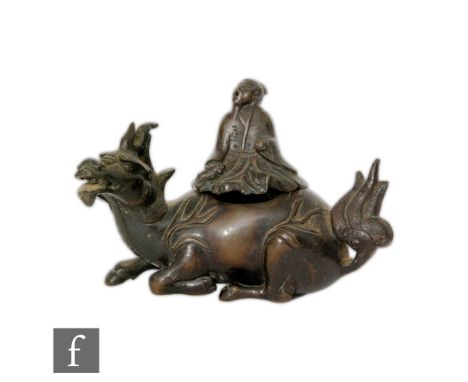 A Chinese late Qing Dynasty (1644-1912) bronze incense burner, modelled as a recumbent Qilin, it hollowed body surmounted by 