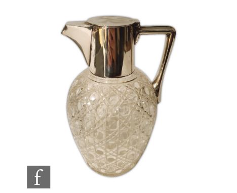 An early 20th Century silver plated and clear glass claret jug, the hob nail cut glass body below a plated collar, hinged lid