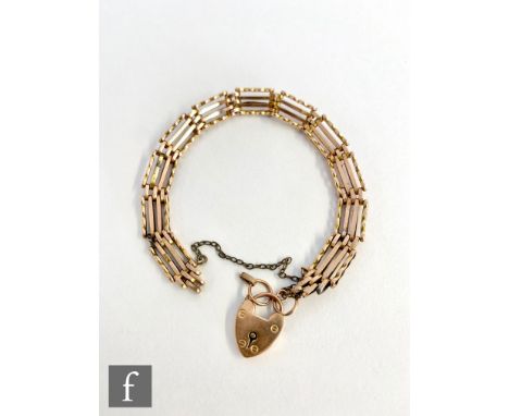 An early 20th Century 9ct rose gold four bar gate bracelet terminating in padlock fastener, weight 9.2g. 