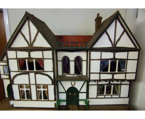 An Edwardian dolls house, in the mock Tudor-style: with hinged double front, enclosing on the ground floor drawing room, kitc