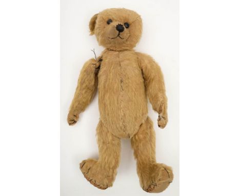An early 20th century blonde plush Teddy:, having boot button eyes and stitched nose and mouth over a jointed body, 36cm high