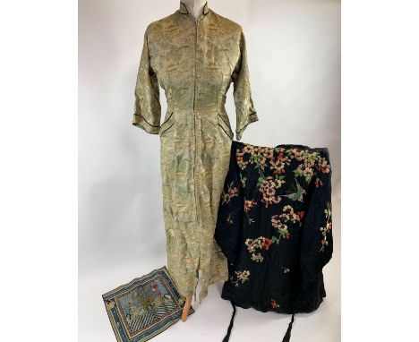 A 20th century black silk kimono, with a synthetic lime green lining, and embroidered decoration of flowers, petals and a but