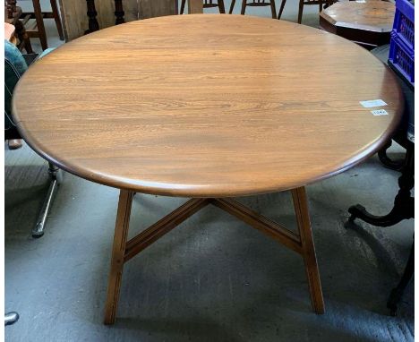 A mid 20th century Ercol round drop leaf dining table and four chairs (two carvers), table top 112.5cm wide (max) x 124cm lon