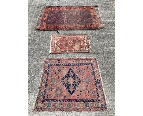 A 20th century rectangular prayer rug, with floral decoration within borders, on a light red ground, 89cm x 57.5cm; a small r