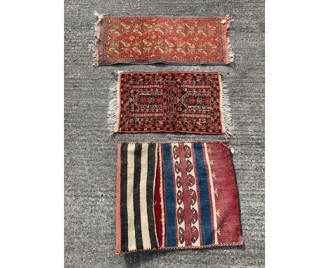 A small rectangular prayer rug with repeating geometric patterns within four borders, on a dark brown ground, 76cm x 50cm; a 