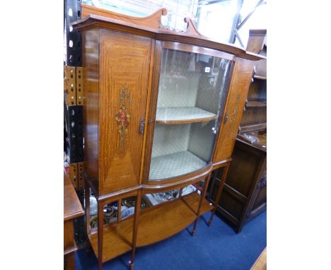 AN EDWARDIAN SATINWOOD BOW FRONTED DISPLAY CABINET, with floral painted decoration, central glazed door flanked by solid door