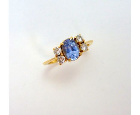 A SAPPHIRE AND DIAMOND RING, the oval shape cornflower blue sapphire flanked by brilliant cut diamonds, estimated total diamo