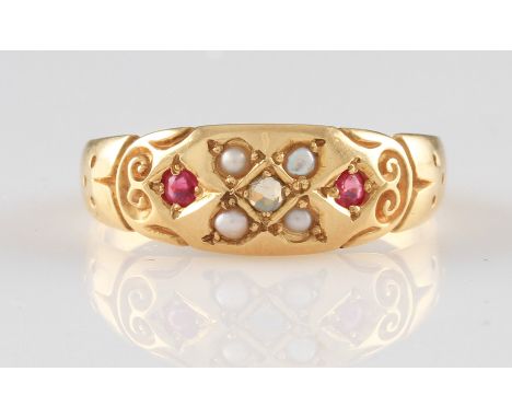 A yellow metal Edwardian style diamond, ruby and seed pearl ring, grain set with a central rose cut diamond surrounded by fou