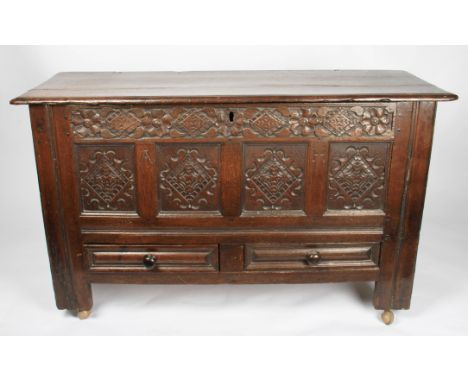 An 18th / 19th Century oak blanket box with carved four panel design to front below floral pattern border with two drawers to