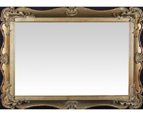 A 19th Century Regency gilt wall mirror with scroll edge design with patterned corners and quarterly central shell decoration
