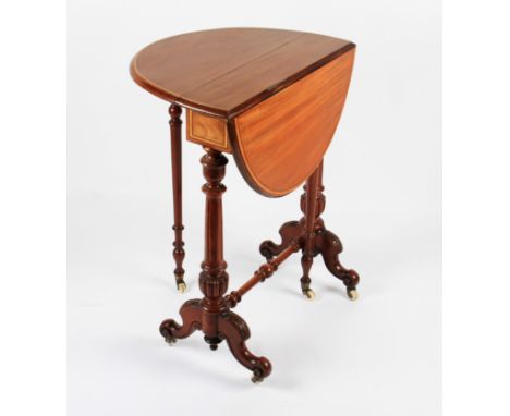 A Victorian mahogany gate leg circular table with light stained inlaid edging on turned supports with shaped legs and ceramic