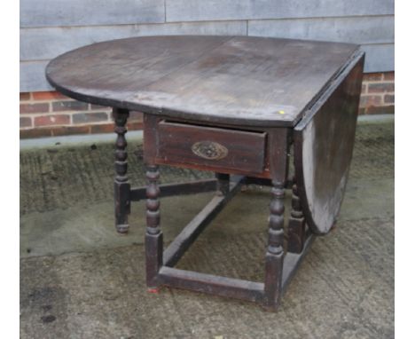 An 18th Century oak oval drop leaf dining table, on bobbin turned supports, 53" long