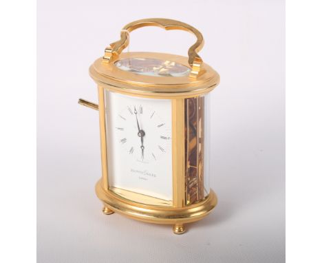 A Mappin & Webb gilded oval cased carriage clock