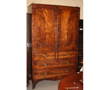 An early 19th Century mahogany linen press, cupboard fitted later shelves enclosed two plain panelled doors, base fitted two 