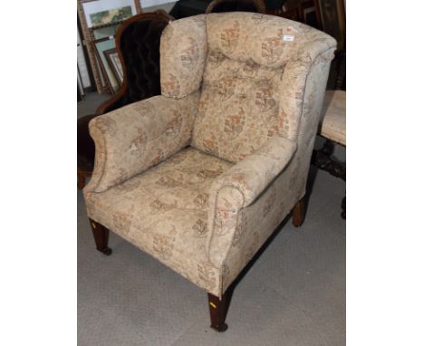 A 19th Century wing armchair, upholstered in a floral tapestry, on square taper supports