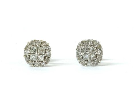 A pair of white gold diamond cluster earrings, with four princess cut diamonds claw set to the centre, to border of graduated