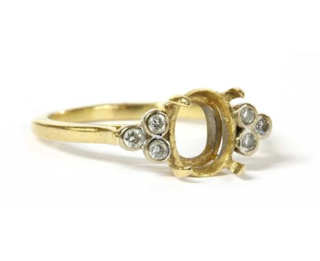 A gold vacant ring mount with diamond shoulders, a vacant four claw oval collet to the centre, with a trefoil of brilliant cu