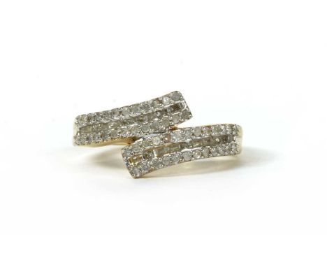 A silver gilt diamond set crossover ring, the crossover band with a row of baguette cut diamonds, channel set, with a row of 