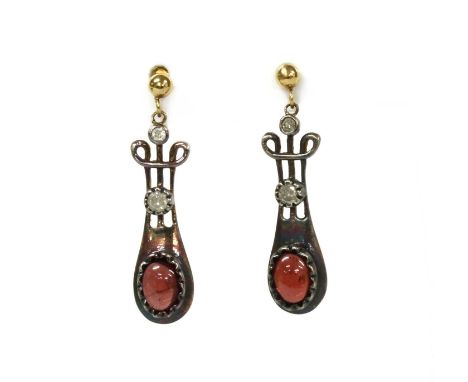 A pair of silver and gold, garnet and diamond drop earrings, lyre shaped links each crimp set to the bottom with an oval cabo