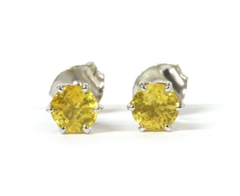 A pair of white gold single stone yellow sapphire stud earrings, a circular mixed cut yellow sapphire, approximately 5mm, six