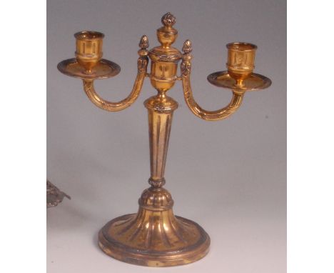 A 19th century French silver gilt twin light candelabrum, supported on tapering fluted column to a circular reeded base, make