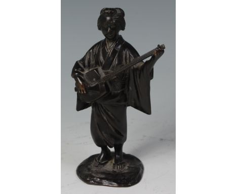 A Japanese Meiji period bronze okimono, the woman in standing pose playing a stringed instrument, signed in script to the bas