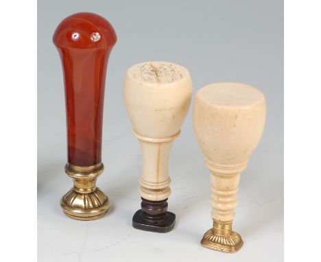 A 19th century ivory and steel desk-seal, the matrix set with a coat of arms and on a turned ivory handle, 8.5cm; one other s