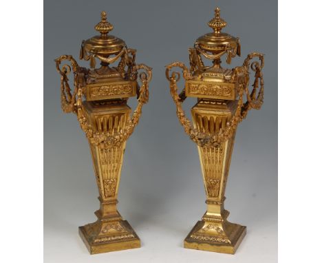 A large pair of French late 19th century gilt bronze chenet, each in the Neo-classical style, with urn finial over still leaf