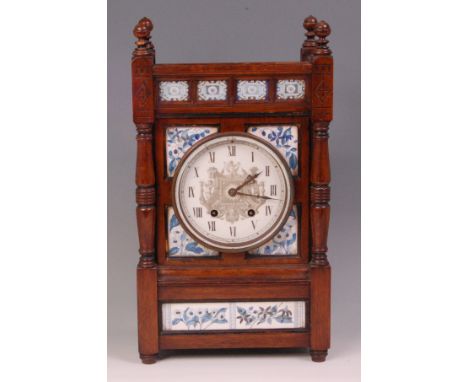 A late 19th century Aesthetic Movement oak mantel clock, inset with soft paste porcelain tiles, the dial with Roman numerals,