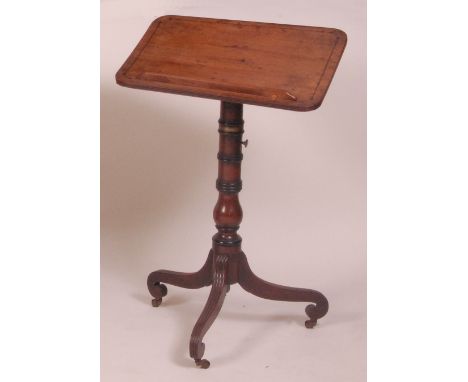 A late Georgian mahogany pedestal reading table, the square top having tilt action, on a ring turned column to three outswept