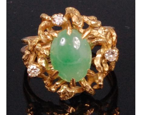 A contemporary ladies yellow metal jade and diamond dress ring, the cabochon jade in a naturalistic openwork setting supporti