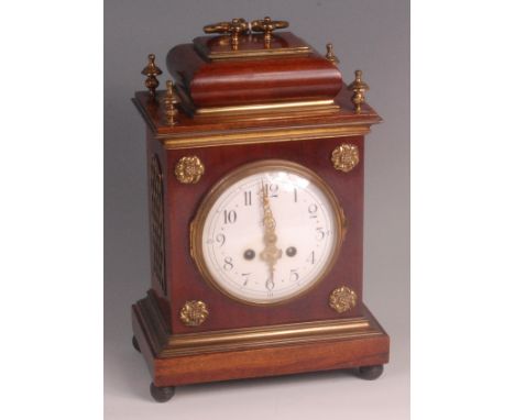 A circa 1900 mahogany cased mantel clock, having brass mounts, convex white enamel dial, twin winding holes for a French bras