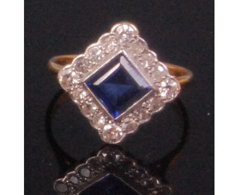 A ladies Art Deco 18ct gold and platinum sapphire and diamond cluster ring, the lozenge set centre baguette cut sapphire (pos