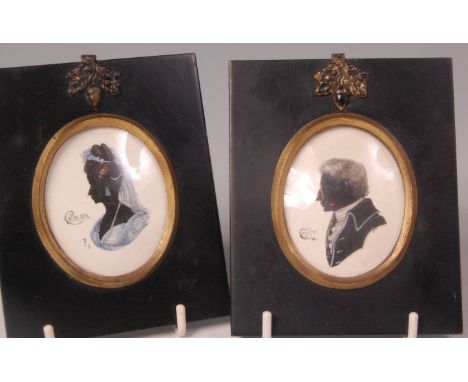 A pair of 19th century portrait silhouettes of an unnamed Lady and Gentleman, heightened in white, both signed with monogram,