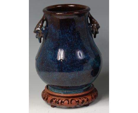 A 19th century Chinese glazed stoneware vase, in the Archaistic style, having applied grotesque mask mounts and seal mark to 