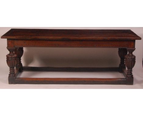 An early 17th century joined and inlaid oak refectory table, having a planked top with cleated ends, the frieze inlaid probab