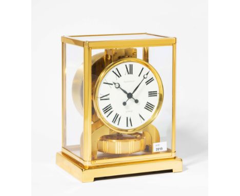 Jaeger-LeCoultre. Allseitig verglastes Gehäuse aus vergoldetem Metall. Weisses, signiertes Zifferblatt mit römischen Ziffern.