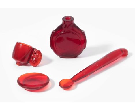 China, 20.Jh. Rotes Glas. 4-teilig: Snuff Bottle, Trichter, Löffel, Schale. Mit Box. H 2,5–11,5 cm. 