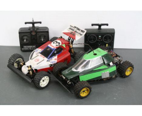 A Kyosho Turbo Optima mid 1/10 scale electric RC 4WD buggy together with a Yokomo RC 4WD belt driven electric buggy, both wit