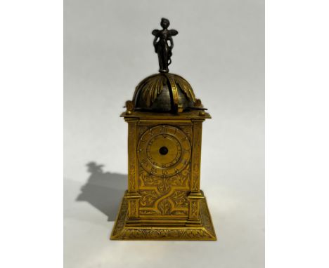 An early 17th Century German engraved gilt brass striking tabernacle style clock. The winged figure standing upon gilt overha