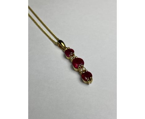 A 14ct yellow gold ruby and diamond pendant, the three graduated round-cut rubies claw set on a vertical bar and spaced by a 