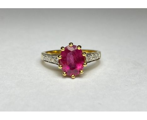 A single stone ruby ring with diamond-set shoulders, the oval-cut ruby claw-set above shoulders each with four graduated roun