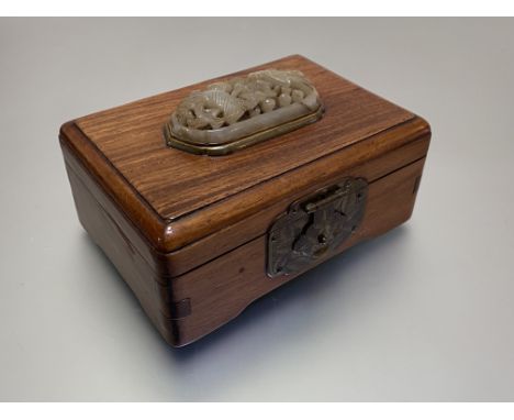 A Chinese carved openwork jade plaque inset into a hardwood box, the pale celadon domed oval plaque carved with birds amidst 